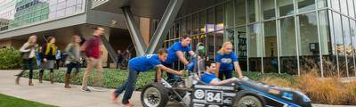 GVSU Formula race car in front of Kennedy Hall of Engineering